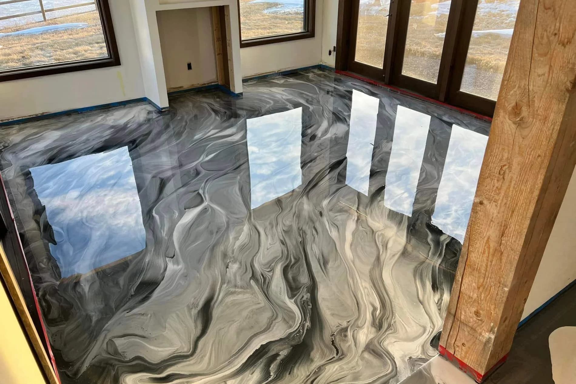 Stunning metallic epoxy flooring with elegant black and silver swirls in a Saudi showroom