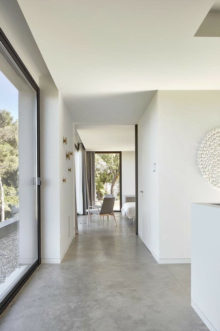 Modern hallway in Riyadh with microcement flooring and outdoor tile landscaping, used to compare cost and dust storm durability against traditional tiles in 2025