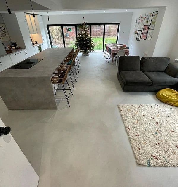 Seamless polished concrete flooring in modern open-plan kitchen and living area with natural daylight