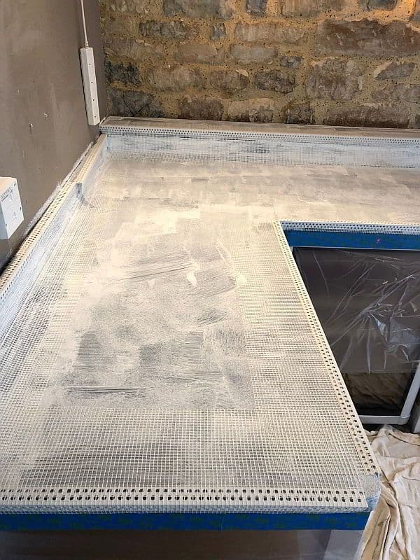 Alkali-resistant fiberglass mesh reinforcement for seamless microcement integrity