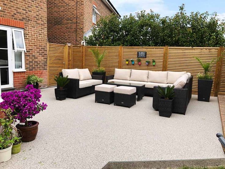 Golden quartz resin-bound driveway at a luxury villa with curved edging and flush drainage channel