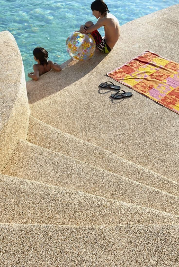 Mixed aggregate resin-bound entrance plaza with decorative band and flush kerb drainage