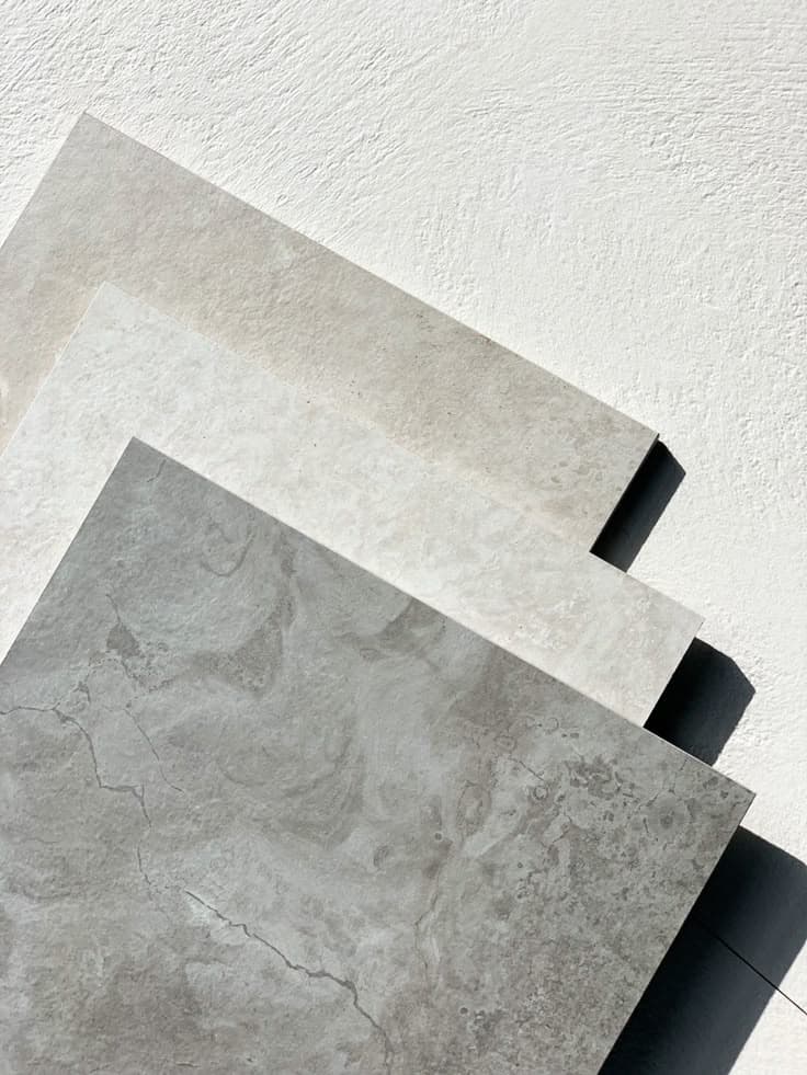 Overlapping samples of neutral-toned microcement for floors.