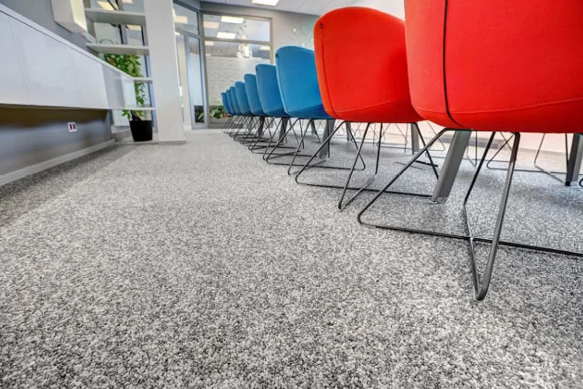Durable resin bound flooring in a modern commercial office reception area with colorful chairs by Floroz in Saudi Arabia