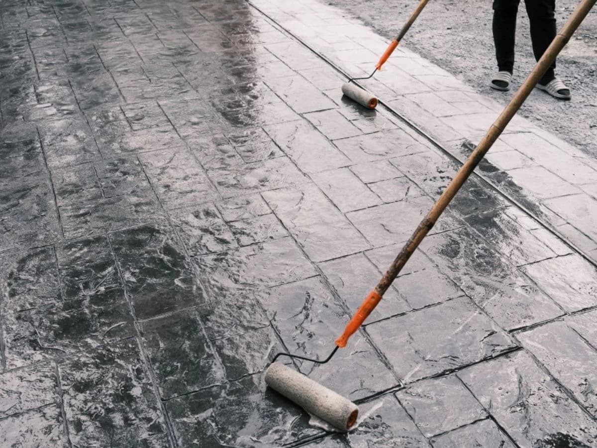 Floroz professional applying protective sealer to stamped concrete surface in Saudi Arabia