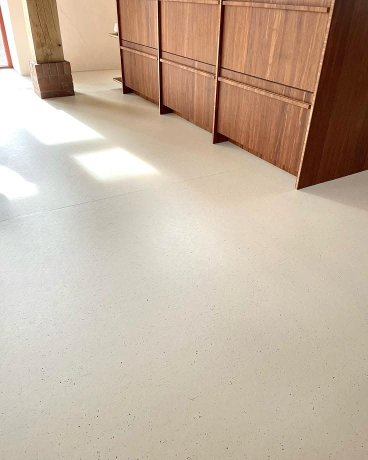 Seamless cream matte epoxy flooring installation for a modern kitchen area.