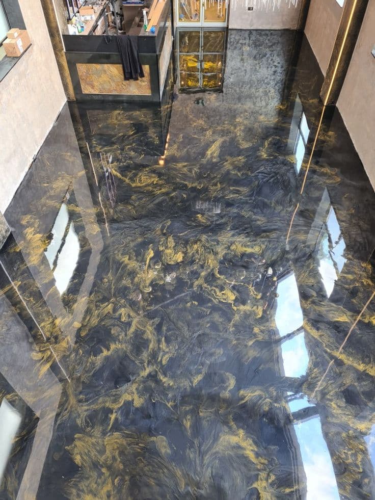 Premium gold and black metallic epoxy flooring for luxury office lobbies and showrooms.