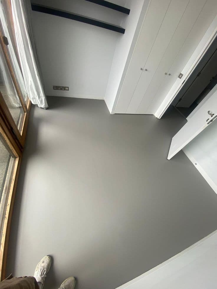 Sleek grey matte epoxy floor coating for a modern bedroom interior design.