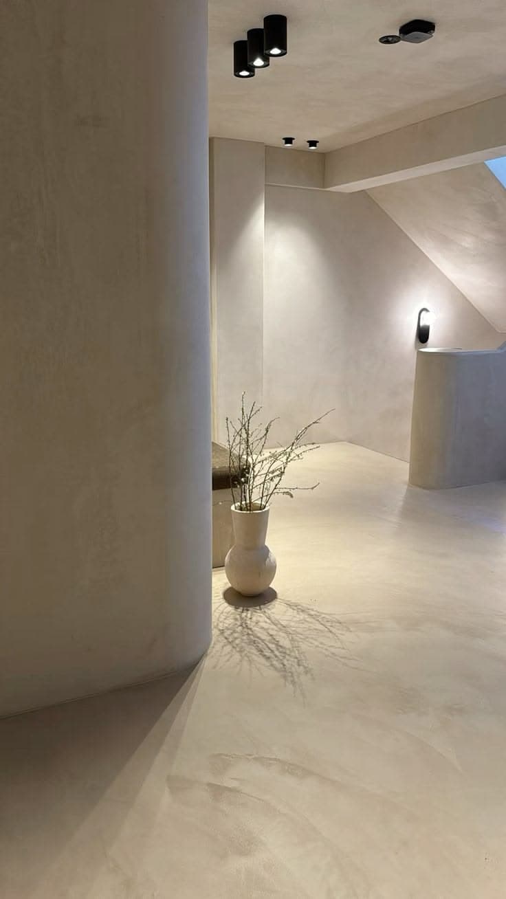 Seamless architectural microcement flooring featuring warm mineral tones and curved wall transitions.