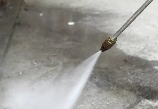 Lithium silicate densifier being applied to an open-pore concrete surface after coarse grinding