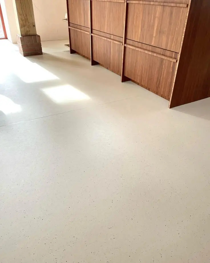 Decorative epoxy floor in a residential kitchen — matte cream finish with seamless surface