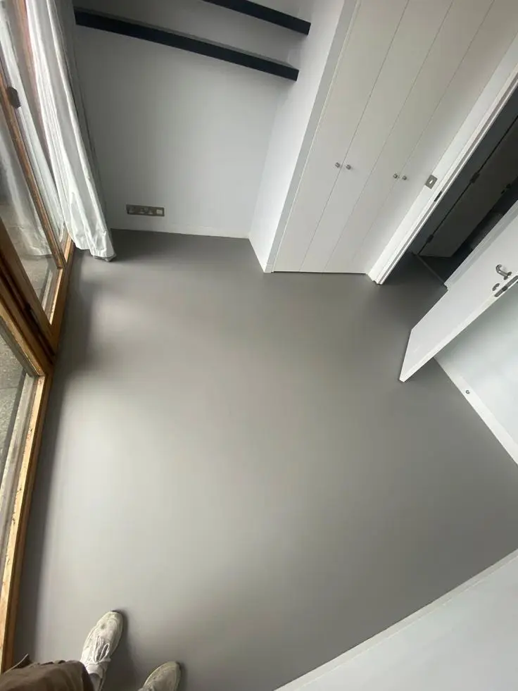 Grey matte epoxy flooring in a bedroom interior — soft, seamless, and light-reflective