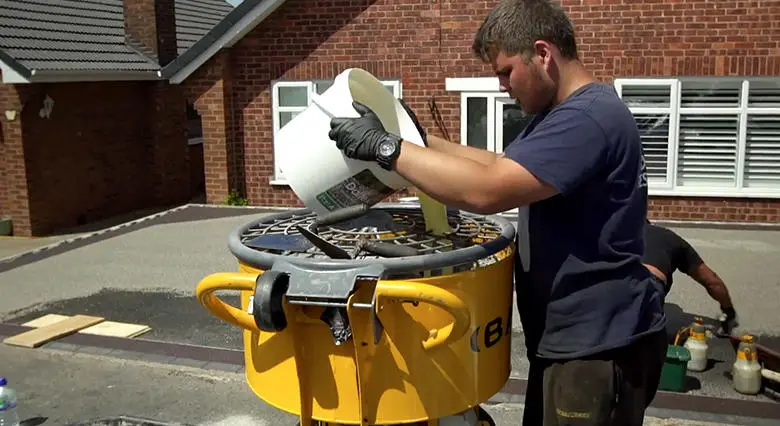 Depth gauge checking compacted resin-bound thickness against specification