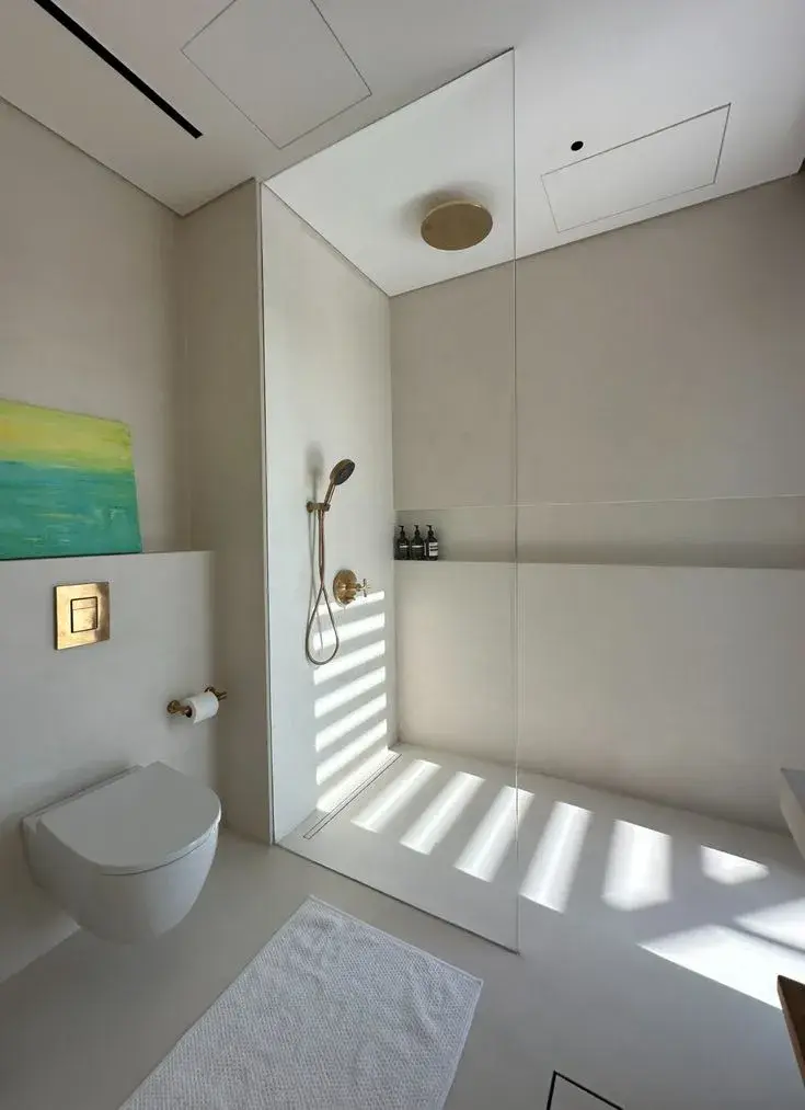 Dark grey microcement shower area with a monolithic finish designed for a high-integrity wet room.