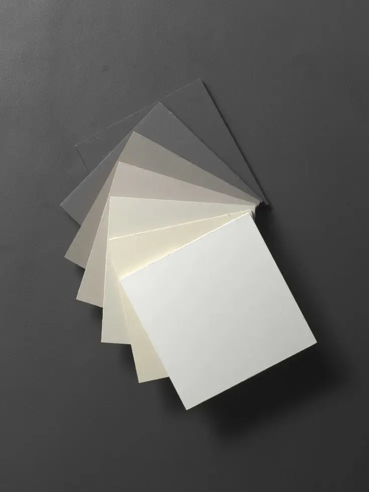 Range of microcement colour samples for kitchens showing shades from mist white to deep steel grey.