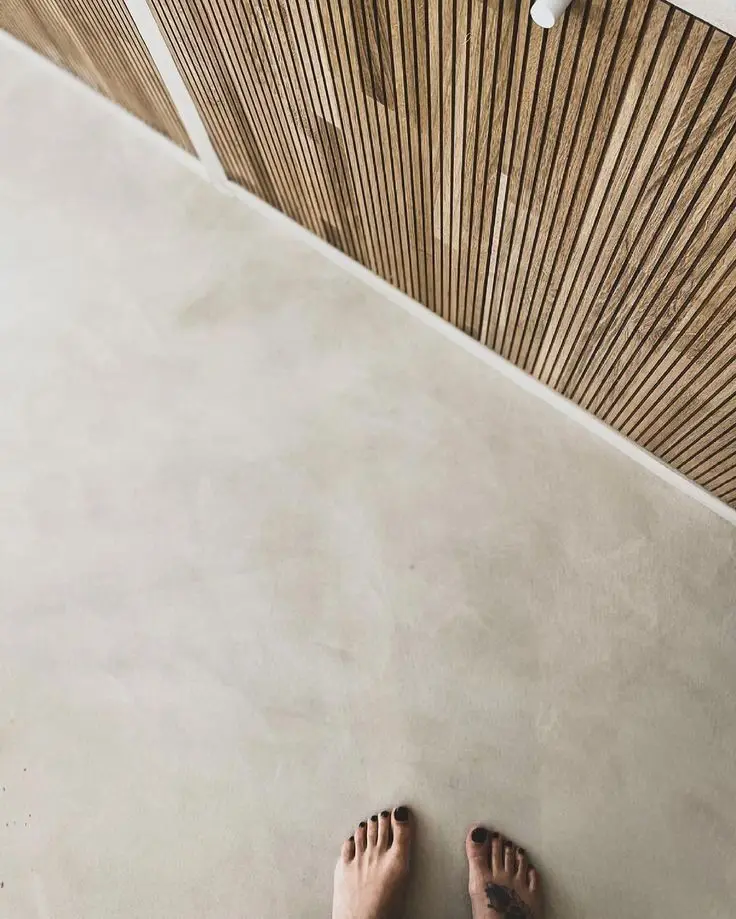 Cream oatmeal microcement kitchen floor with a warm light-reflecting mineral finish paired with wood accents.