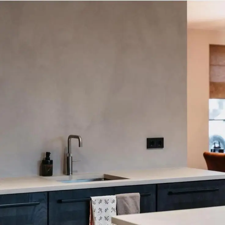 Steel grey microcement worktop and splashback with a coarse mineral grain for an industrial kitchen.