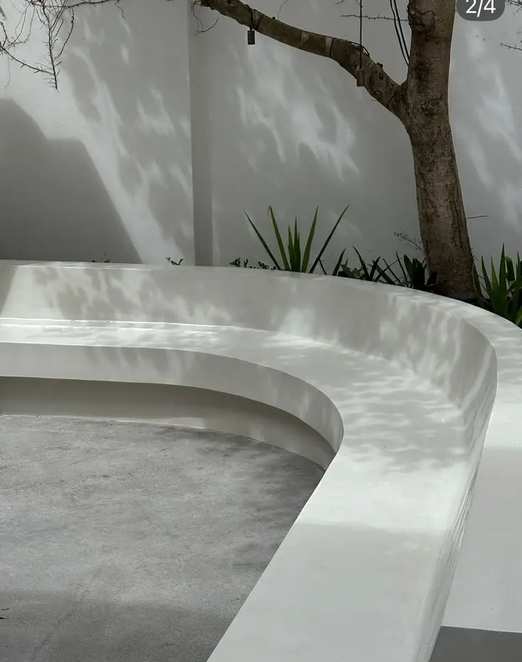 Seamless white microcement curved outdoor bench and floor with no joints or grout lines
