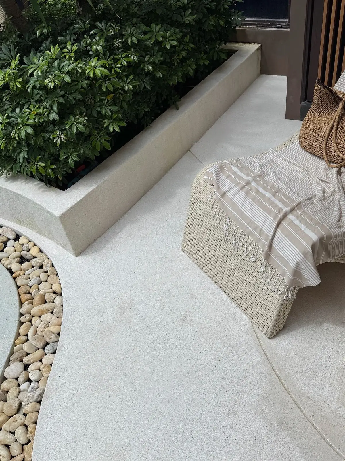 Light mineral seamless microcement outdoor patio floor with planter box and seating area