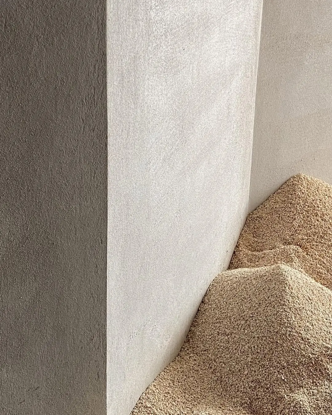 Light grey textured microcement outdoor wall and facade finish showing mineral texture detail