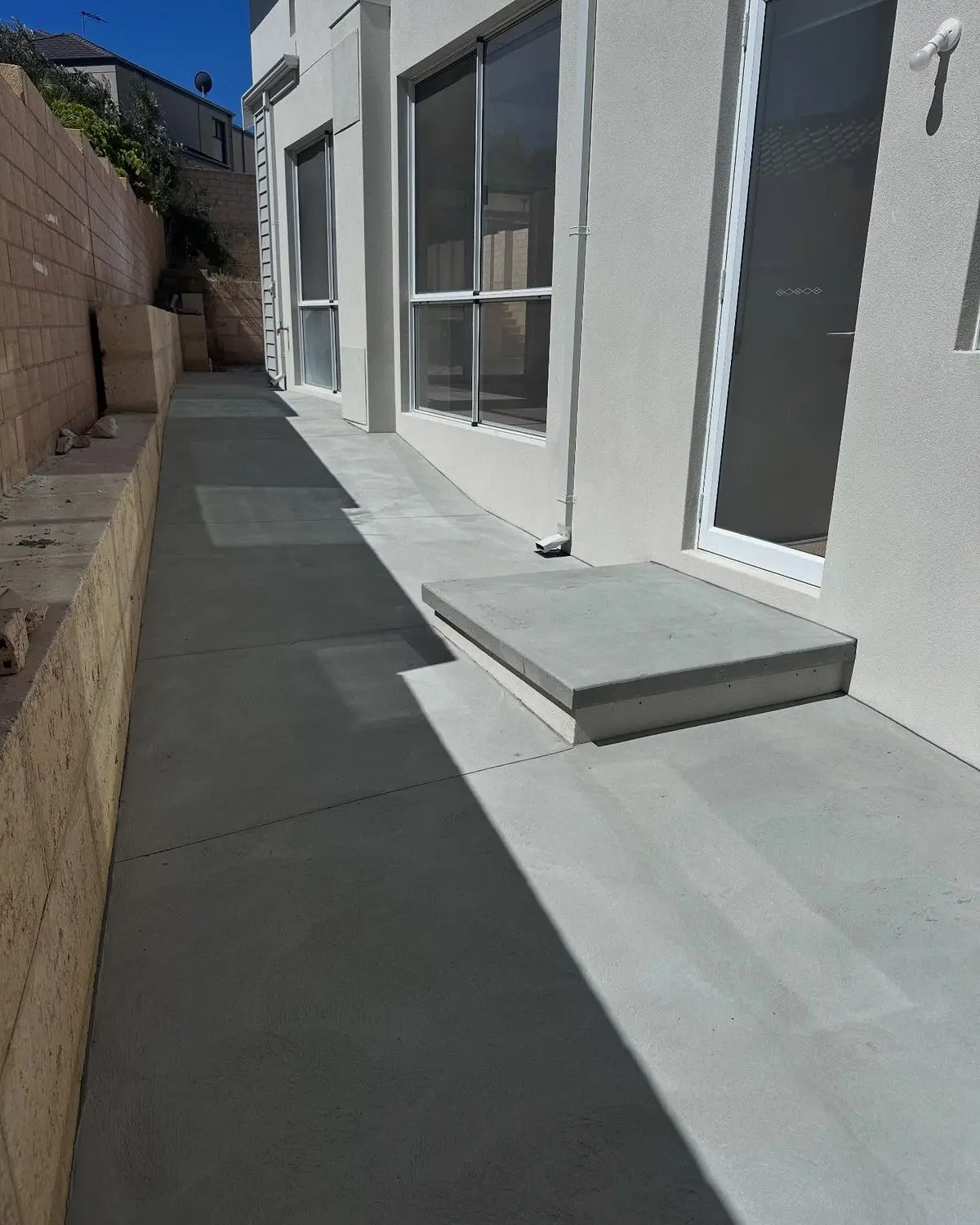 Seamless grey microcement outdoor pathway along exterior villa wall